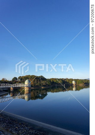 The lake surface and water intake tower of Lake Tama in the blue sky in autumn located on the Sayama Hills 97200678