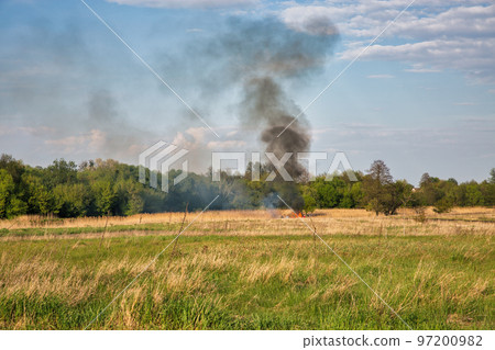 People burn a huge fire in the field 97200982