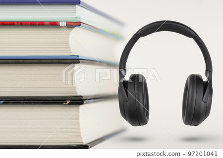 Audiobooks. Audiobook concept, stack of books and headphones with space for copy space. Choice between books and audio. 97201041
