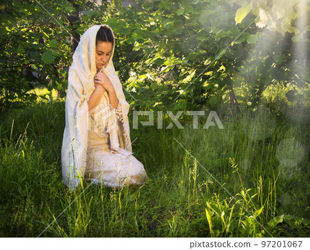 Praying woman in ancient light clothes Praying woman in ancient light clothes 97201067