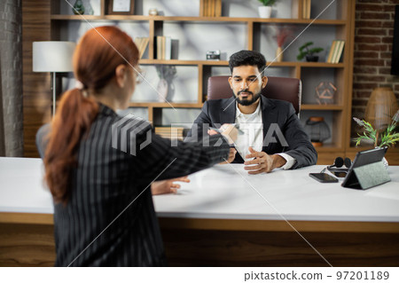 Back view of young red hair businesswoman giving bribe to smiling confident bearded businessman Back view of young red hair businesswoman giving bribe to smiling confident bearded businessman 97201189
