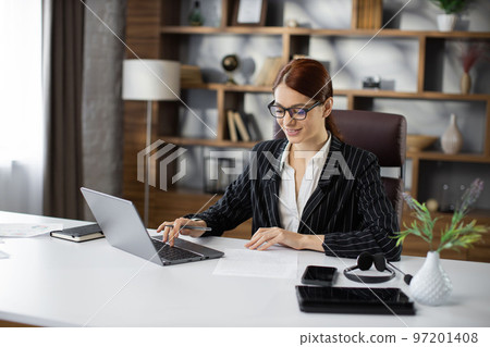 Businesswoman working on laptop in modern office. Businesswoman working on laptop in modern office. 97201408