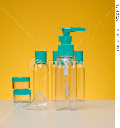 Transparent plastic bottles for liquid cosmetics on a yellow background Transparent plastic bottles for liquid cosmetics on a yellow background 97201458