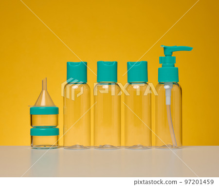 Transparent plastic bottles for liquid cosmetics on a yellow background 97201459