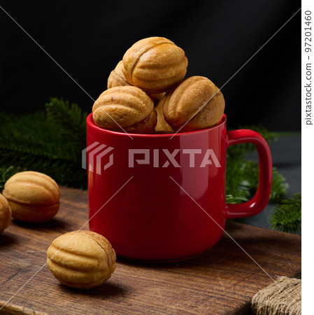 Baked nut-shaped dessert in a red ceramic mug Baked nut-shaped dessert in a red ceramic mug 97201460