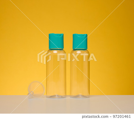 Transparent plastic bottles for liquid cosmetics on a yellow background Transparent plastic bottles for liquid cosmetics on a yellow background 97201461