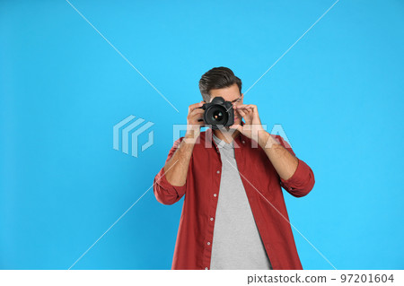 Professional photographer working on light blue background in studio. Space for text 97201604