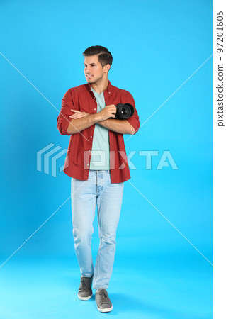Professional photographer working on light blue background in studio Professional photographer working on light blue background in studio 97201605
