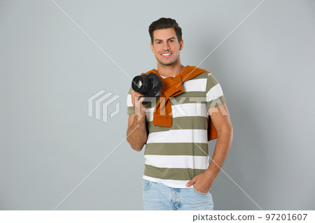 Professional photographer working on light grey background in studio Professional photographer working on light grey background in studio 97201607