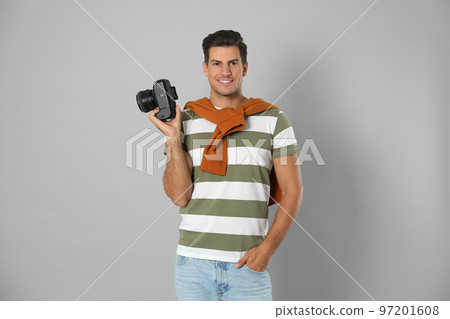 Professional photographer working on light grey background in studio Professional photographer working on light grey background in studio 97201608