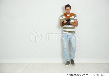 Professional photographer working near white wall in studio. Space for text Professional photographer working near white wall in studio. Space for text 97201609