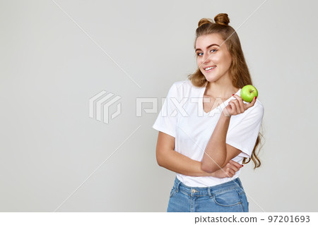 girl holding green apple on studio background 97201693