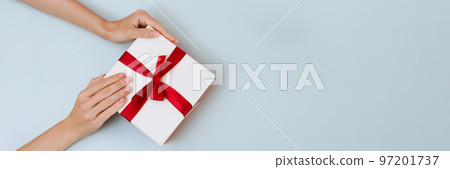 Banner women's hands hold a white with a red ribbon bow 97201737