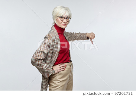 beautiful elderly woman with glasses gives a thumbs down. the concept of a business woman leader beautiful elderly woman with glasses gives a thumbs down. the concept of a business woman leader 97201751