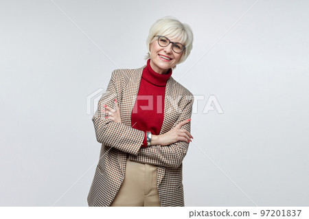 beautiful elderly woman with glasses poses in front of the camera in the studio on a white background. advertising concept of a business woman leader beautiful elderly woman with glasses poses in front of the camera in the studio on a white background. advertising concept of a business woman leader 97201837