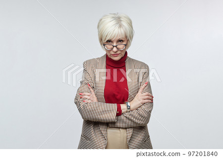 beautiful elderly woman with glasses poses in front of the camera in the studio on a white background. advertising concept of a business woman leader beautiful elderly woman with glasses poses in front of the camera in the studio on a white background. advertising concept of a business woman leader 97201840