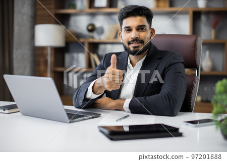Confident young middle eastern businessman sitting at work table 97201888