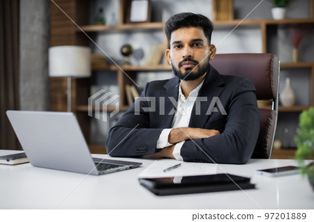 Confident young middle eastern businessman sitting at work table 97201889