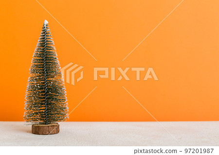 One small Christmas tree on colored background. new year decoration with copy space 97201987