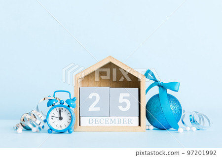 25 december. Christmas composition on colored background with a wooden calendar, with a gift box, toys, bauble copy space 97201992