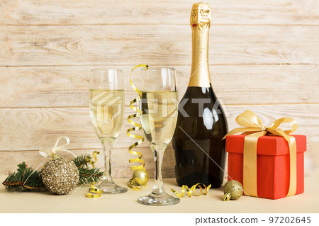 Champagne bottle with confetti, glasses and christmas decor on colored holiday background. Flat lay New Year decorations 97202645