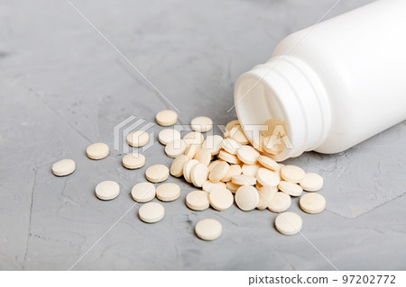 different drugs and health supplement pills poured from a medicine bottle health care and medical top view on colored background 97202772