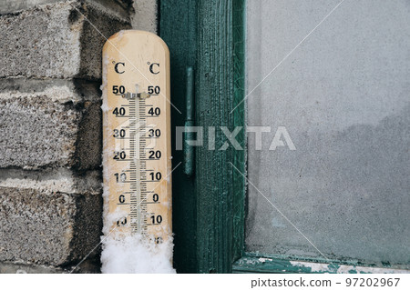 Snow covered outdoor thermometer on windowsill. Winter, weather forecast and temperature measure concept. Freeing season. Frozen glass of old green wooden window. Blurred brick wall. Snow covered outdoor thermometer on windowsill. Winter, weather forecast and temperature measure concept. Freeing season. Frozen glass of old green wooden window. Blurred brick wall. 97202967