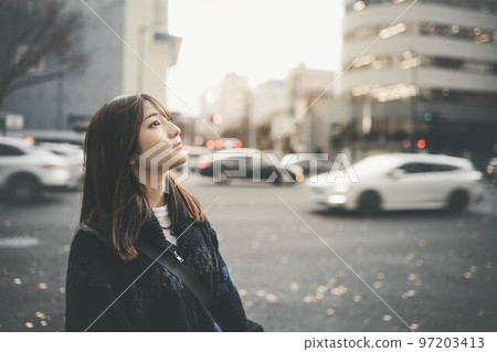 Woman standing at a crossroads in the city Woman standing at a crossroads in the city 97203413