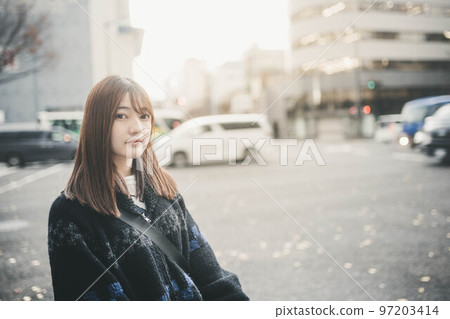 Woman standing at a crossroads in the city 97203414