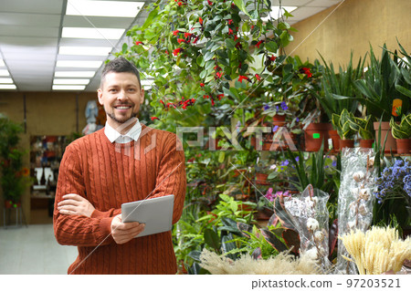 Male business owner with tablet in his flower shop 97203521