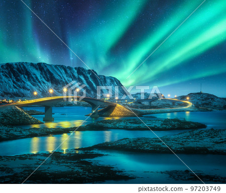 Bridge and northern lights over snowy mountains. Lofoten islands 97203749