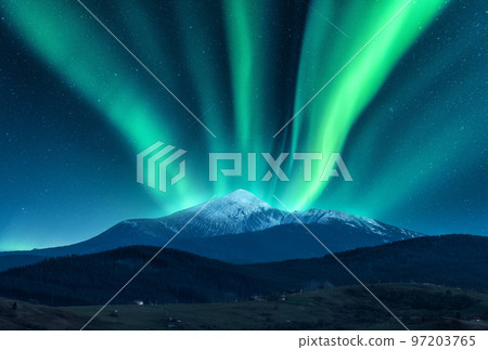 Aurora borealis over the snow covered mountain peak 97203765