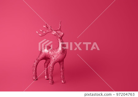 Sparkling deer decoration for Christmas. Deer figurine isolated on Viva Magenta color background. Christmas symbol. Silver glitter stag decoration. Viva Magenta toning, color 2023. 97204763