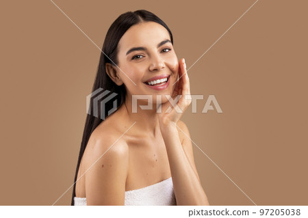 Cheerful attractive woman posing topless over beige background, touching face Cheerful attractive woman posing topless over beige background, touching face 97205038