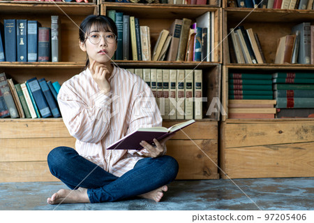 Young woman relaxing and reading in a chic room Young woman relaxing and reading in a chic room 97205406