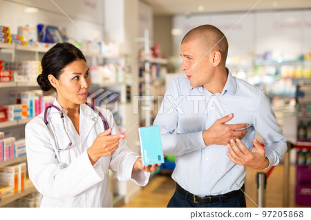 Female pharmacist consulting client in drugstore Female pharmacist consulting client in drugstore 97205868