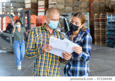 Man and young woman in masks talking about documentation Man and young woman in masks talking about documentation 97206046