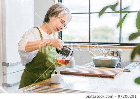 Asian elderly woman brewing coffee in the kitchen of the house/cafe Asian elderly woman brewing coffee in the kitchen of the house/cafe 97206291