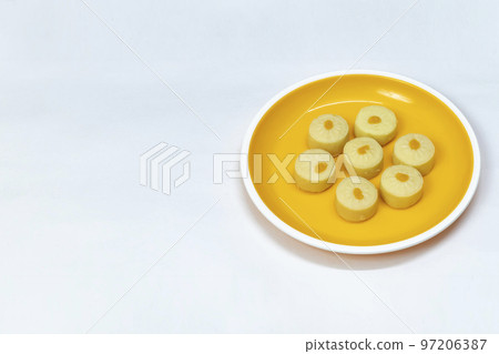 Indian sweets (Bhalkoa) served on yellow plate on white background, selective focus 97206387