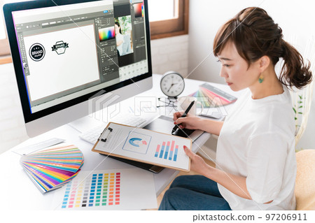 A graphic designer woman who designs a logo while looking at data 97206911