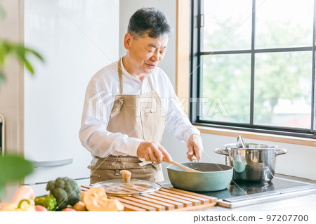 Elderly Asian man cooking homemade food using a frying pan in the kitchen at home (smile) 97207700
