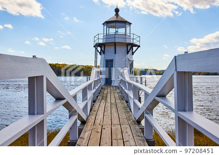 White Maine lighthouse with wood boardwalk and railing 97208451