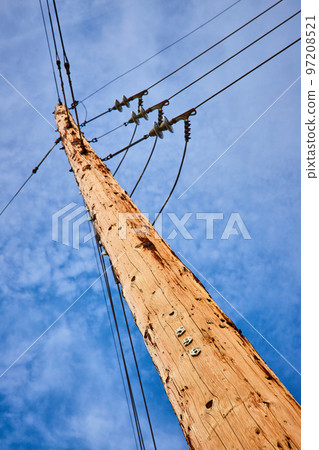 Looking up at light brown telephone pole with blue sky and numbers 5 9 6 on it Looking up at light brown telephone pole with blue sky and numbers 5 9 6 on it 97208521