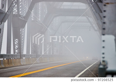 Looking down old steel bridge on extreme foggy morning with cars Looking down old steel bridge on extreme foggy morning with cars 97208525
