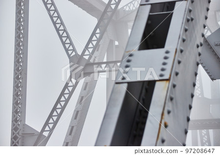 Foggy morning detail of steel beams on bridge Foggy morning detail of steel beams on bridge 97208647