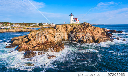 Huge rocky island with lighthouse on Maine coast aerial with waves crashing over rocks 97208963