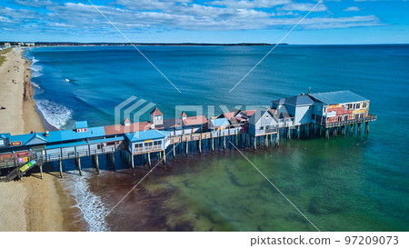 Beach on Maine ocean aerial over large wood pier covered in shops 97209073