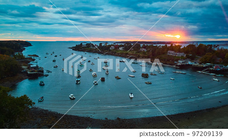Maine bay at sunset filled with ships and boats and golden glow of sun 97209139