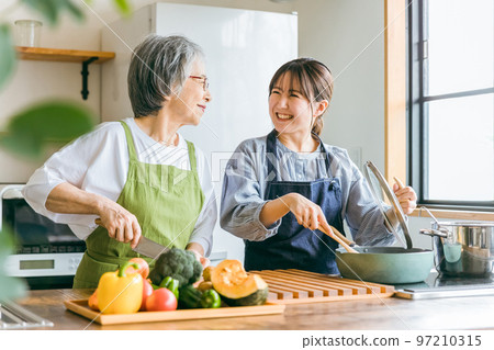 微笑的亞洲老年婦女和年輕婦女在家裡的廚房裡一起做飯、做家務和自己做飯（管家/家政代理） 97210315