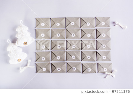 Envelopes for the advent calendar in a rectangle and knitted fir trees on a gray background Envelopes for the advent calendar in a rectangle and knitted fir trees on a gray background 97211376